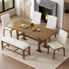 a dining room table with white chairs and a fireplace