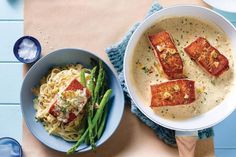 two bowls filled with food on top of a table