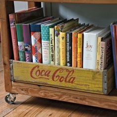 a wooden crate filled with books on top of a hard wood floor next to a book shelf