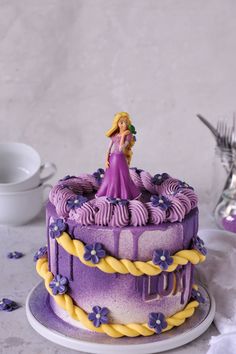 there is a purple cake with a princess figure on top