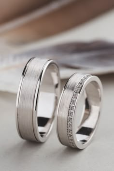 two wedding rings sitting on top of a table