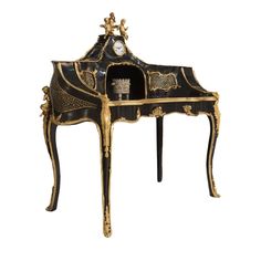 an ornate black and gold desk with clock on it's top, sitting against a white background