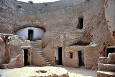 the interior of a cave with stairs leading to two small rooms and one door open