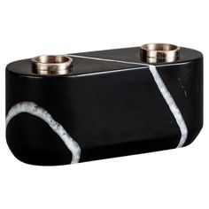 a black and white marble candle holder with two candles