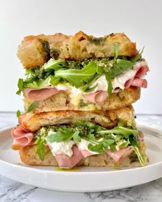 two sandwiches stacked on top of each other with meat and veggies in the middle