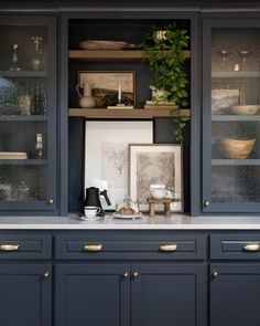 a kitchen with blue cabinets and white counter tops, gold trim on the doors and brass knobs