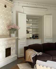 a living room filled with furniture and a fire place in front of a white fireplace