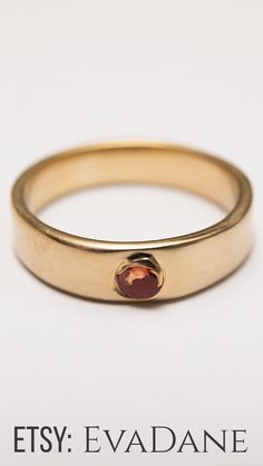 a gold ring with a red stone in the middle