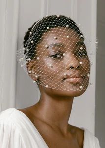 a woman wearing a veil with pearls on it