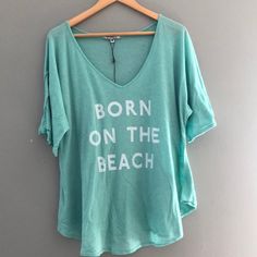 Wildfox New Born On The Beach Tee Never Worn. Turquoise Color Green Summer Tops For Loungewear, Light Blue Tops For Vacation, Light Blue Relaxed Fit Beach Top, Light Blue V-neck Top For Beach Season, Light Blue Summer Tops For Beach, Light Blue Relaxed Fit Summer Top, Light Blue Graphic Print Top For Loungewear, Turquoise Casual Summer Tops, Casual Turquoise Tops For Summer