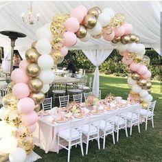 a table set up for a party with pink and gold balloons