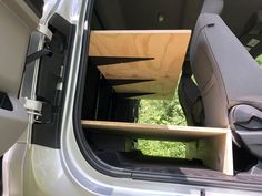 the interior of a van with wooden shelves in the back seat and seats folded down