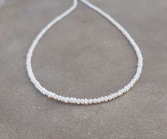 "2mm minimalist beaded pearls necklace/chocker Seed pearls necklace/chocker,made with tiny seed pearls - natural fresh water pearls. 14K solid gold clasp please select :spring ring or fish lock(see picture) Minimalist ,delicate necklace beautiful alone or stacked with other necklaces for the layered look Important: these natual pearls tiny size need gentle care- avoid sleeping,sweaming,shower with the necklace. Measures : Seed pearls - 2mm- 2.2mm Necklace length- please select from drop down men Affordable White Pearl Necklace With Tiny Beads, Dainty Handmade Pearl Necklace For Anniversary, Dainty Single Strand Beaded Necklaces For Wedding, Dainty Single Strand Beaded Necklace For Wedding, Delicate Beaded Necklaces With Tiny Beads For Gifts, Delicate Beaded Necklaces With Tiny Beads As Gift, Delicate Tiny Beaded Necklaces For Gifts, Delicate Beaded Necklaces With Pearl Drop, Dainty Beaded Necklace With Pearl Pendant As Gift