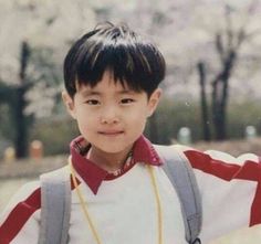 the young boy is wearing a backpack and smiling