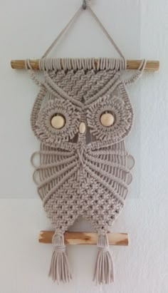 a crocheted owl is hanging on the wall