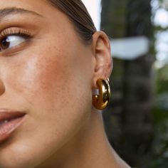 Meet the Bella Earrings, a stunning statement hoop here to add some drama to your outfit! These chunky golden hoops are truly flawless and are sure to elevate your look day or night.  Our styling tips: Pair Bella with a bold statement necklace like Isla for a stand out look. Crafted with precision, these earrings showcase a 14k gold plating (1 micron) over a stainless steel base. Finished with e-coating for added shine, they are both lead and nickel free, ensuring safe wear for all.   CARING FOR YOUR AOE JEWELS  At Arms Of Eve, we take great pride in the quality of all our jewels. All of our pieces are suitable for daily wear. Our jewels are 100% nickel and lead free. All our pieces are plated 1 microns thick in 14k Gold, as well as an e-coating for a premium finish.  In order for your jew Gold Earrings Chunky, Gold Chunky Earrings, Chunky Gold Earrings Stack, Bold Gold Drop Earrings, Chunky Gold Metal Earrings, Chunky Loop Gold Earrings, Thick Gold Hoop Earrings, Thick Gold Hoops, Chunky Gold Hoop Earrings