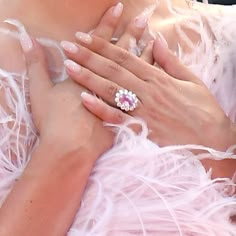 the woman is wearing a pink dress and diamond ring