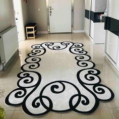 a black and white rug in the middle of a hallway with an ornate design on it