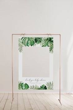 a white frame with green leaves on it