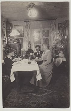 an old black and white photo of three people sitting at a table in a dining room