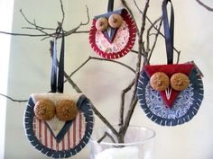 three ornaments are hanging from a tree branch