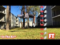 a person jumping in the air on a trampoline near some buildings and trees