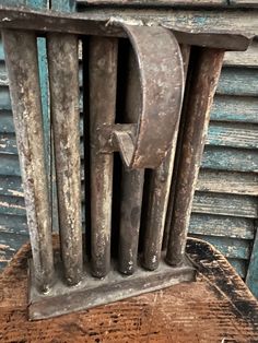 an old metal object sitting on top of a wooden table