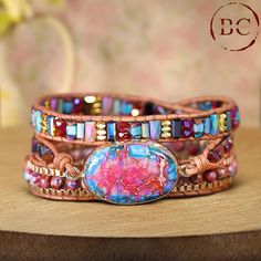 This popular jewelry piece features a Natural Stone Pink Jaspers Beaded Leather Wrap Bracelet, designed for a distinctive boho flair. The bracelet showcases beautifully strung pink jasper beads, known for their vibrant hues, wrapped around a supple leather strap. With its triple-layered design, it offers a bold and stylish statement, perfect for adding a touch of elegance to any outfit. Ideal for women who appreciate both bohemian style and natural beauty and makes for a thoughtful friendship gi Multicolor Beaded Spiritual Leather Bracelet, Bohemian Wrap Bracelet With Natural Stones, Bohemian Adjustable Leather Bracelet With Colorful Beads, Bohemian Beaded Wrap Bracelet Bangle, Bohemian Gemstone Beads Wrap Bracelet For Festivals, Adjustable Bohemian Leather Bracelet With Colorful Beads, Bohemian Wrap Bracelet With Gemstone Beads For Festivals, Bohemian Hand-strung Wrap Bangle Bracelet, Handmade Multicolor Bohemian Crystal Bracelet