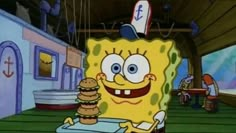 spongebob holding a hamburger in front of his face