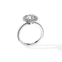 a white gold ring with diamonds on the band and an oval center stone in the middle