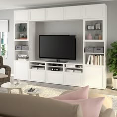 a living room with furniture and a flat screen tv on top of a wooden entertainment center