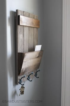 a wooden wall hanging on the side of a white wall next to a key rack