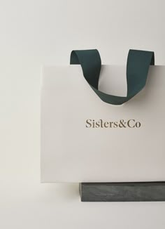 a paper bag that says sisters & co on it