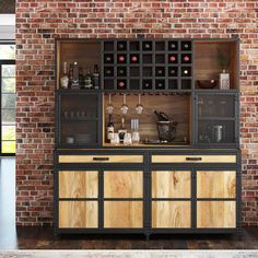 a wooden cabinet with wine glasses and bottles on it in front of a brick wall