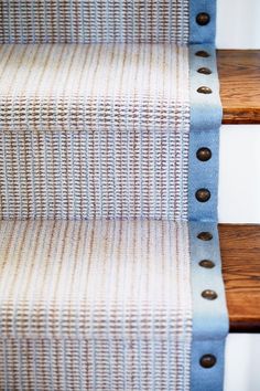 a close up view of some stairs with blue and white fabric on them, as well as wooden handrails