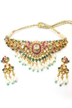 This Natural Ruby with Pearl and Emerald Necklace Set is a dazzling example of luxury and craftsmanship, meticulously designed to highlight the beauty of natural gemstones and the elegance of traditional jewelry. Crafted in 18k gold, this necklace is a masterpiece that showcases a harmonious blend of rubies, pearls, emeralds, and Polki diamonds. The necklace features vivid natural rubies, their deep red hue radiating passion and elegance. These rubies are perfectly complemented by the rich green of the emeralds, creating a striking contrast that is both eye-catching and sophisticated. Interspersed between the rubies and emeralds are lustrous pearls, adding a touch of softness and refinement to the piece. The pearls' subtle sheen enhances the necklace's overall elegance, balancing the bold Emerald Necklace Set, Polki Diamond Necklace, Rich Green, Emerald Necklace, Traditional Jewelry, Natural Ruby, Handmade Necklace, Necklace Handmade, Deep Red