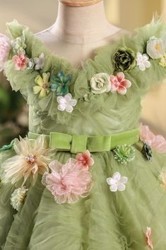 This beautiful sage green flower girl dress features a princess silhouette and crossed straps on the back. Made with high-quality tulle fabric and adorned with delicate flowers, it's perfect for any special occasion such as baptisms, birthdays, weddings, and more. The floor length design and sleeveless, round neckline add an elegant touch.