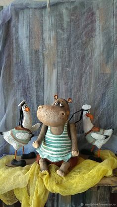 a stuffed hippo sitting on top of a wooden table next to ducks and geese