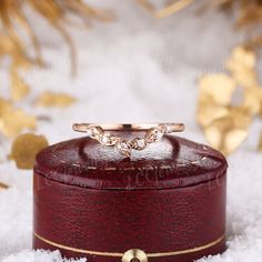 a red box with a ring on top of it in the middle of some snow