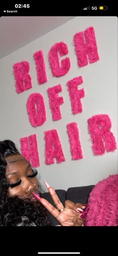 a woman sitting on top of a couch holding a pink toothbrush