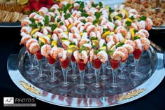 there are many different types of appetizers in wine glasses on the trays