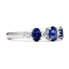 Our Oriana Ring features a slightly larger oval shaped sapphire set at the center with two graduating sizes set on each side. Between each of the sapphires are shimmering round diamonds whose colorless hues offer a clear contrast from the deep royal blue shades of each sapphire. This timeless creation will certainly make for a wonderful alternative engagement band. Metal: 18kt Gold Sapphire Weight: 1.30 ct. Diamond Weight: 0.28 ct. *Please note that the listed ct. weights are approximate and may Oval Sapphire Ring In Diamond White, Timeless Three-stone Sapphire Diamond Ring, Timeless Sapphire Three-stone Diamond Ring, Timeless Three-stone Sapphire Ring, Oval Sapphire Ring With Three Stones, Timeless Oval Sapphire Ring With Prong Setting, Oval Sapphire Diamond White Ring, Oval Sapphire Diamond Ring In Diamond White, Oval Sapphire Diamond Ring With Accents