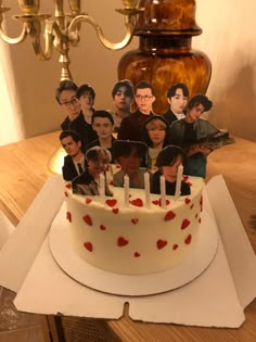 a cake with many people on it and candles in the shape of heart - shaped hearts