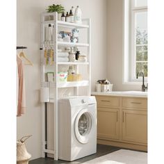 a washer and dryer in a room next to a window with shelves on the wall