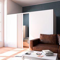 a living room with a brown leather couch and white table in front of the window