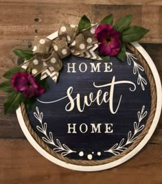 a sign that says home sweet home with flowers on it