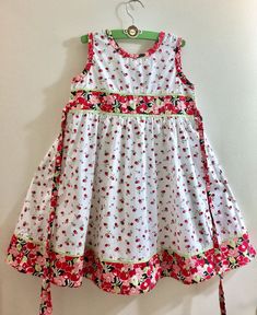 "This classic sleeveless dress for young girls is the perfect outfit for a special occasion as well as casual wear. With red cherry pattern on white and wide long straps that ties to the bow on the back, this sundress has a crew neck opening on the front. The back of the bodice is designed with 3- button closure. The material is lightweight, making it perfect as a summer or spring dress. This dress is great for formal events like christenings, weddings, birthdays, parties, and more. Great for Ea Toddler Bows, Rose Pastel, Spring Dress, Flower Dresses, Dress With Bow, Formal Event, Sundress, Perfect Outfit, Red Dress