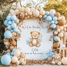 a teddy bear themed baby shower with blue and white balloons on the arch, it says we are babies first