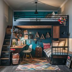 a loft bed with desk underneath and stairs leading up to the top floor, in front of a blue wall