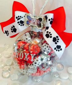 a glass ornament filled with candies and dog paw prints on it's side